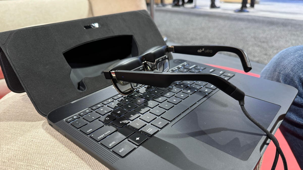 A laptop stand with trackpad and keyboard with smart glasses installed and sitting on them, called Spacetop.